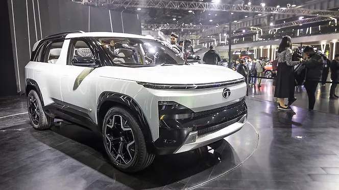 The Tata Sierra EV showcased at an event, featuring a modern design with a white exterior, futuristic styling, and black alloy wheels.